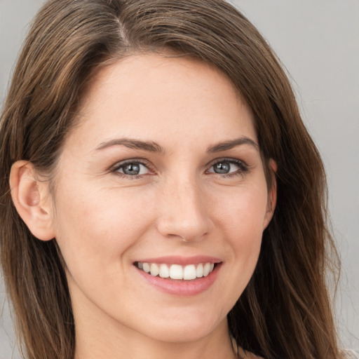 Joyful white young-adult female with long  brown hair and brown eyes