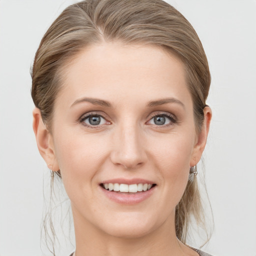 Joyful white young-adult female with medium  brown hair and blue eyes