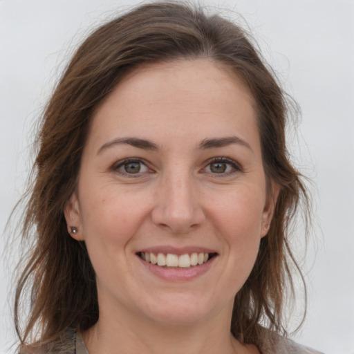 Joyful white young-adult female with long  brown hair and grey eyes