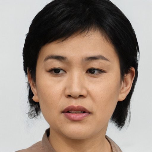 Joyful asian young-adult female with medium  black hair and brown eyes