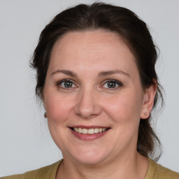 Joyful white adult female with medium  brown hair and grey eyes