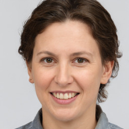 Joyful white adult female with medium  brown hair and grey eyes