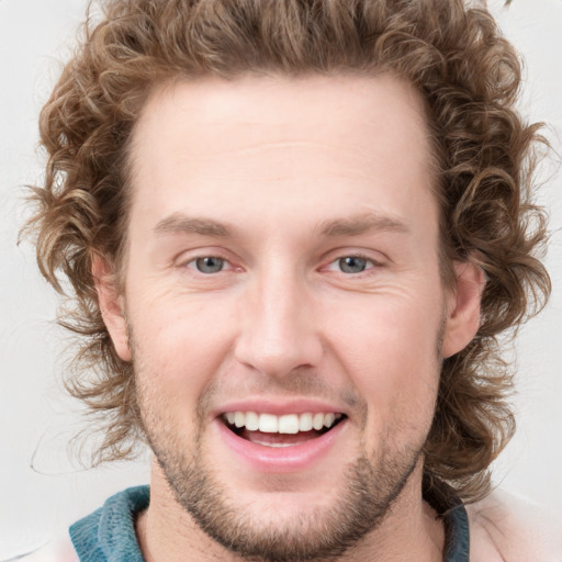 Joyful white young-adult male with short  brown hair and blue eyes