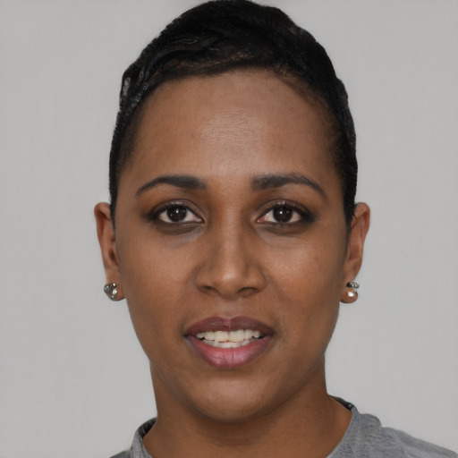 Joyful black young-adult female with short  black hair and brown eyes