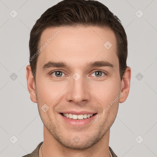 Joyful white young-adult male with short  brown hair and grey eyes