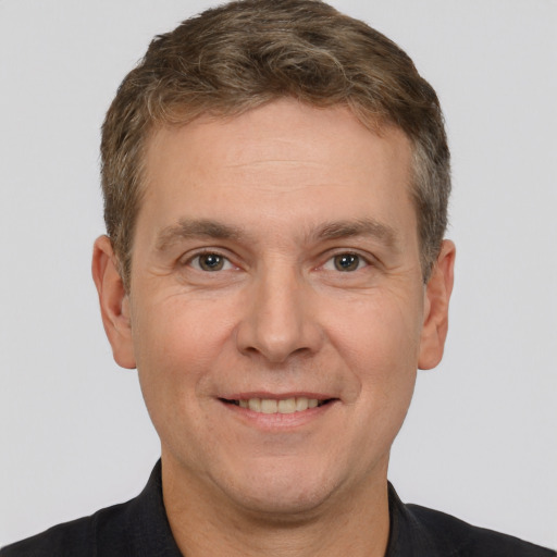 Joyful white adult male with short  brown hair and brown eyes