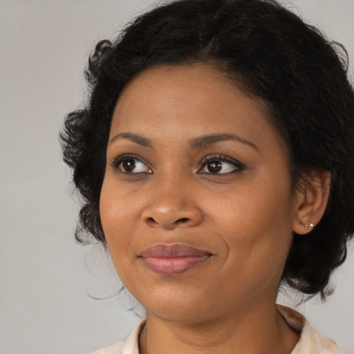 Joyful black adult female with medium  brown hair and brown eyes