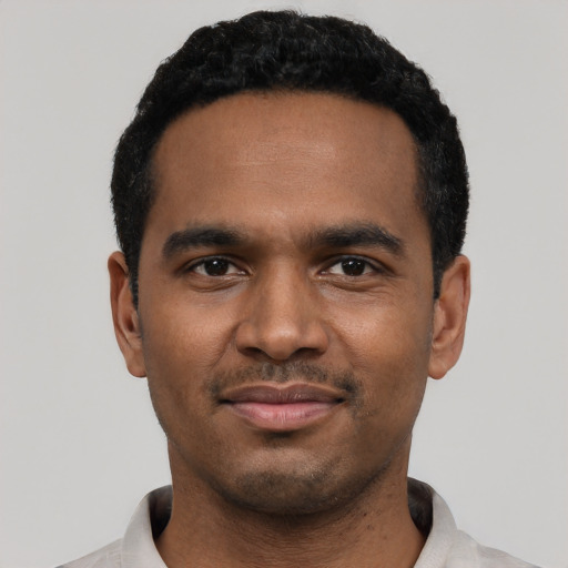 Joyful black young-adult male with short  black hair and brown eyes
