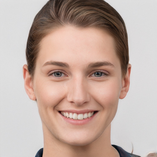 Joyful white young-adult female with short  brown hair and grey eyes