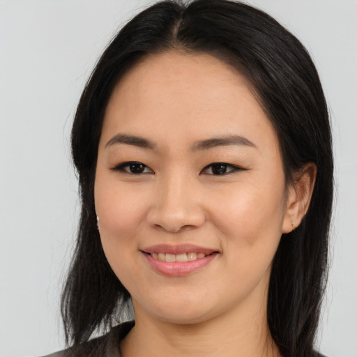 Joyful asian young-adult female with long  black hair and brown eyes