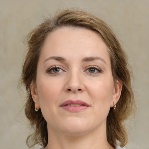 Joyful white young-adult female with medium  brown hair and grey eyes