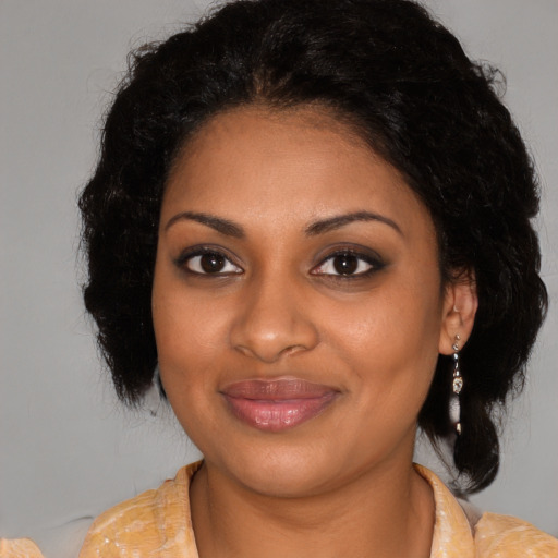 Joyful black young-adult female with medium  brown hair and brown eyes