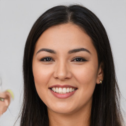 Joyful latino young-adult female with long  brown hair and brown eyes