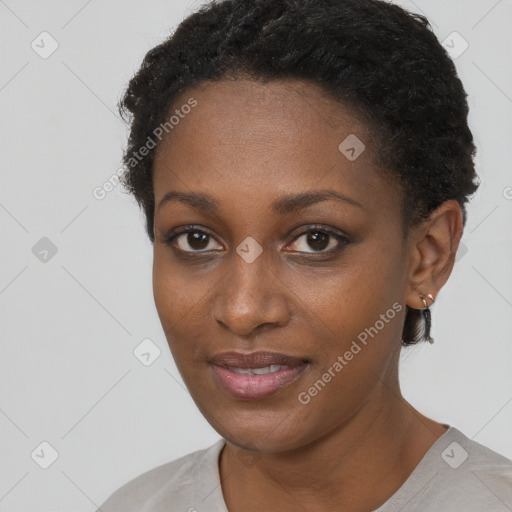 Joyful black young-adult female with short  black hair and brown eyes