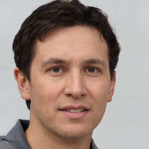 Joyful white adult male with short  brown hair and grey eyes