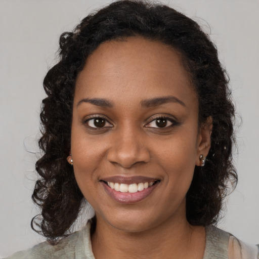 Joyful black young-adult female with long  brown hair and brown eyes