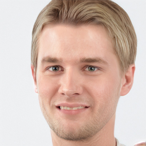 Joyful white young-adult male with short  brown hair and blue eyes