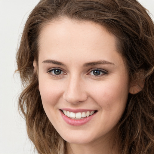 Joyful white young-adult female with long  brown hair and green eyes