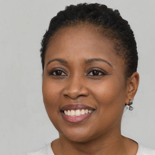 Joyful black young-adult female with short  brown hair and brown eyes