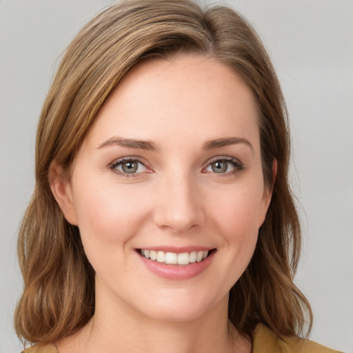 Joyful white young-adult female with medium  brown hair and blue eyes