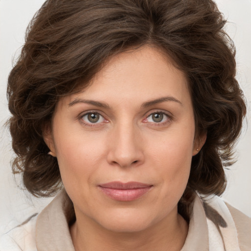 Joyful white young-adult female with medium  brown hair and green eyes