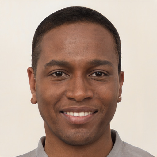 Joyful black young-adult male with short  brown hair and brown eyes