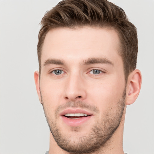 Joyful white young-adult male with short  brown hair and grey eyes