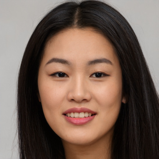 Joyful asian young-adult female with long  brown hair and brown eyes