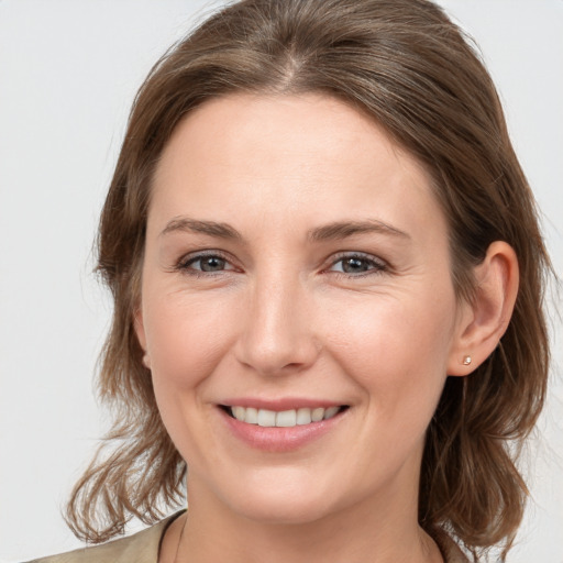 Joyful white young-adult female with medium  brown hair and grey eyes