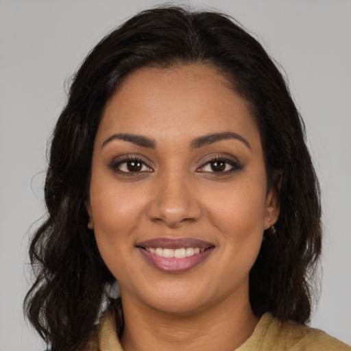 Joyful black young-adult female with long  brown hair and brown eyes