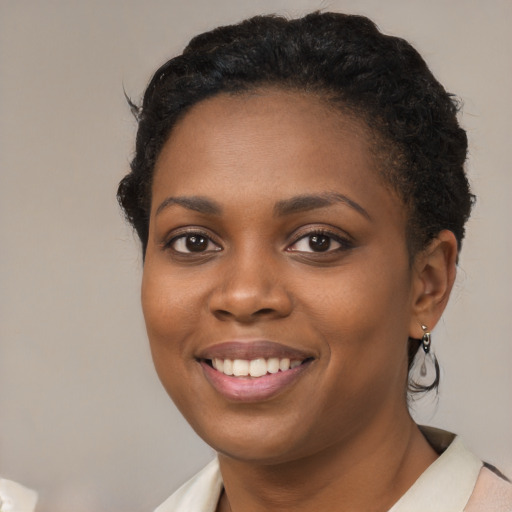 Joyful black young-adult female with short  brown hair and brown eyes