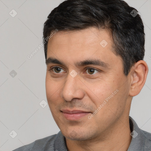 Joyful white young-adult male with short  black hair and brown eyes