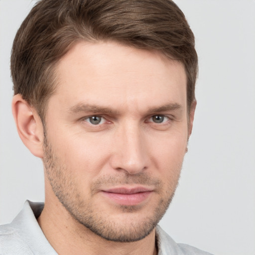 Joyful white young-adult male with short  brown hair and grey eyes