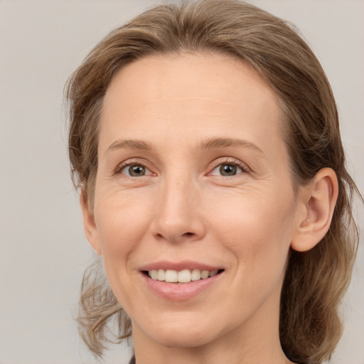 Joyful white adult female with medium  brown hair and grey eyes