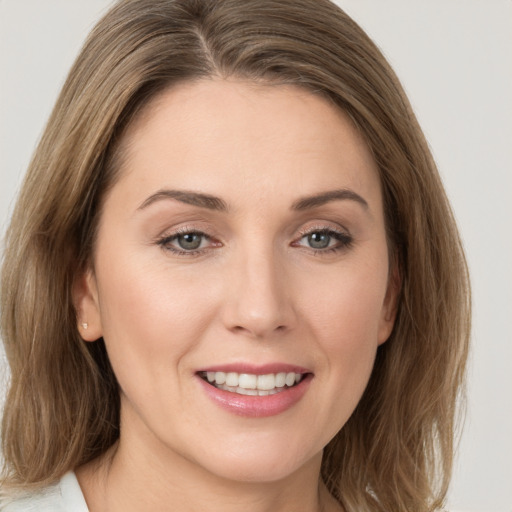 Joyful white young-adult female with medium  brown hair and green eyes