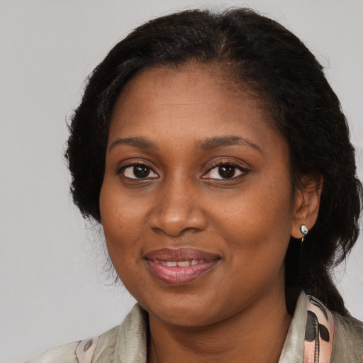 Joyful black young-adult female with long  brown hair and brown eyes