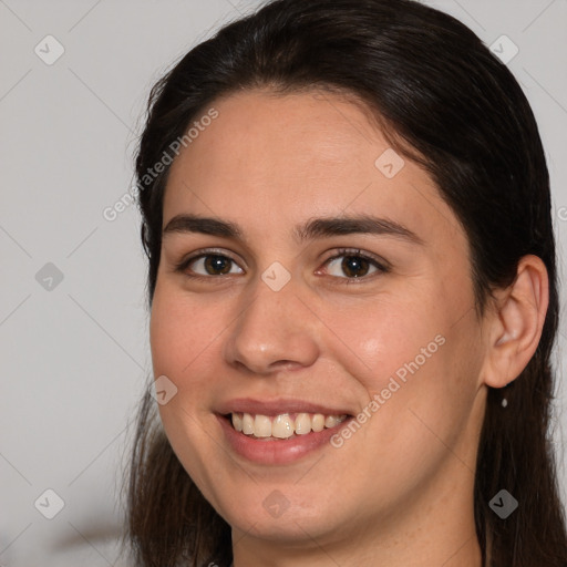 Joyful white young-adult female with long  brown hair and brown eyes