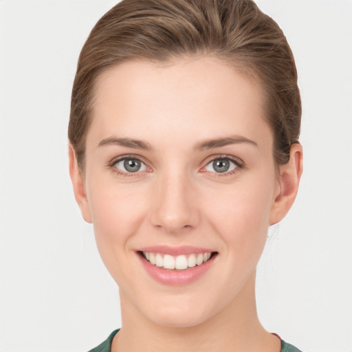 Joyful white young-adult female with short  brown hair and green eyes