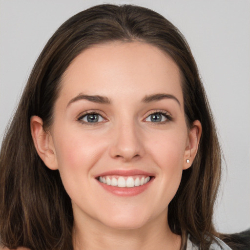 Joyful white young-adult female with long  brown hair and grey eyes