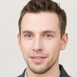 Joyful white young-adult male with short  brown hair and grey eyes