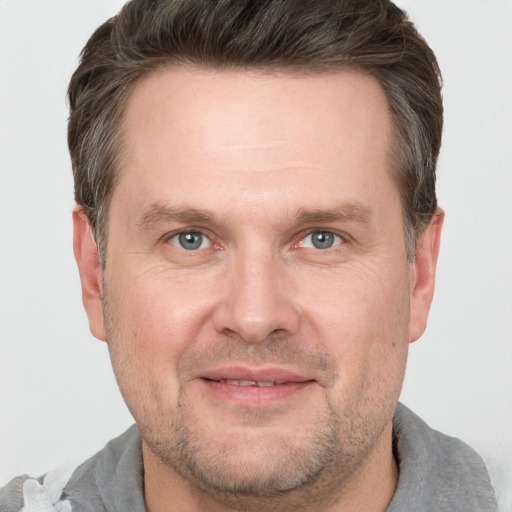 Joyful white adult male with short  brown hair and grey eyes