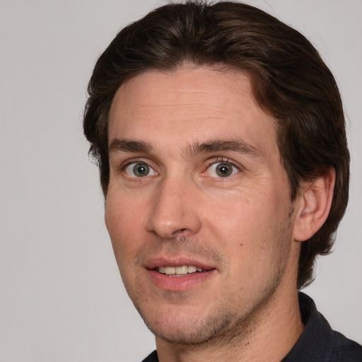 Joyful white adult male with short  brown hair and grey eyes