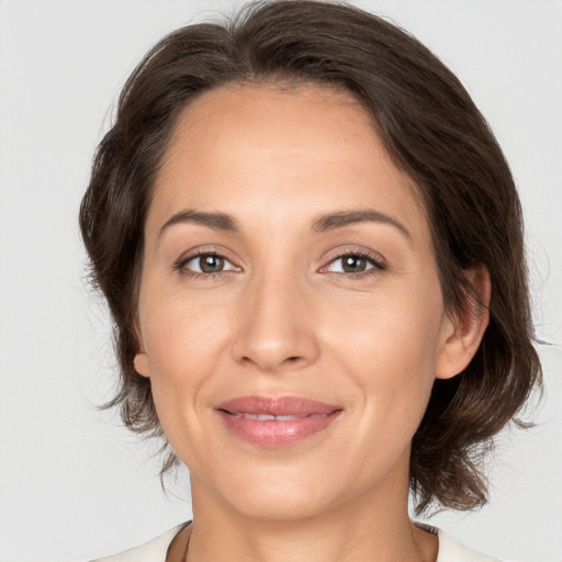 Joyful white adult female with medium  brown hair and brown eyes