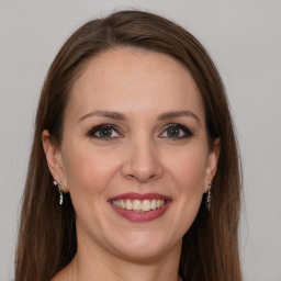 Joyful white young-adult female with long  brown hair and grey eyes