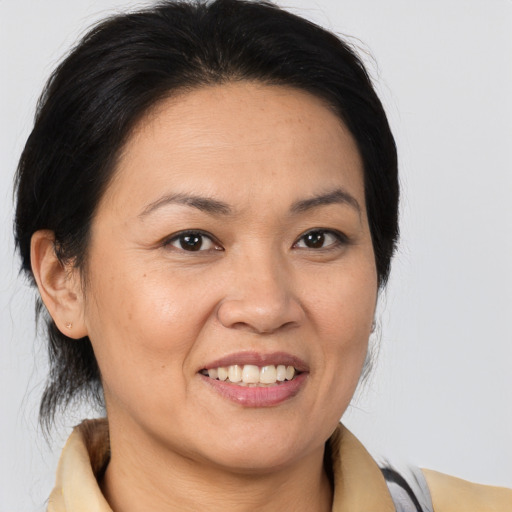 Joyful latino adult female with medium  brown hair and brown eyes