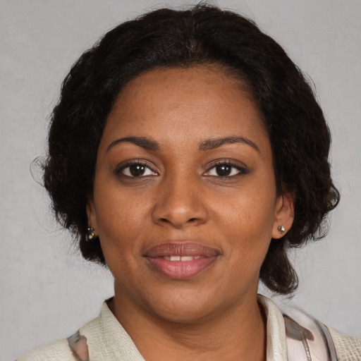 Joyful black young-adult female with medium  brown hair and brown eyes