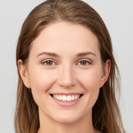 Joyful white young-adult female with long  brown hair and grey eyes