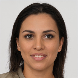 Joyful latino young-adult female with long  brown hair and brown eyes