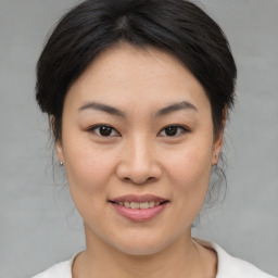 Joyful asian young-adult female with medium  brown hair and brown eyes