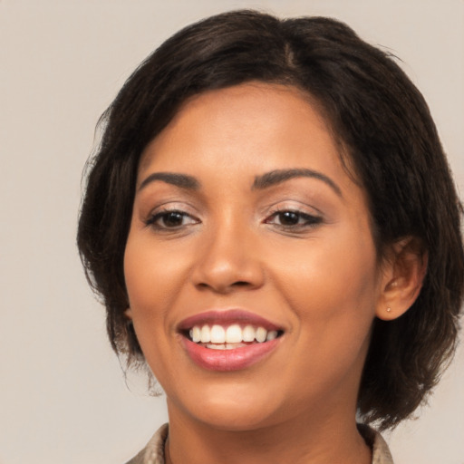 Joyful latino young-adult female with medium  brown hair and brown eyes